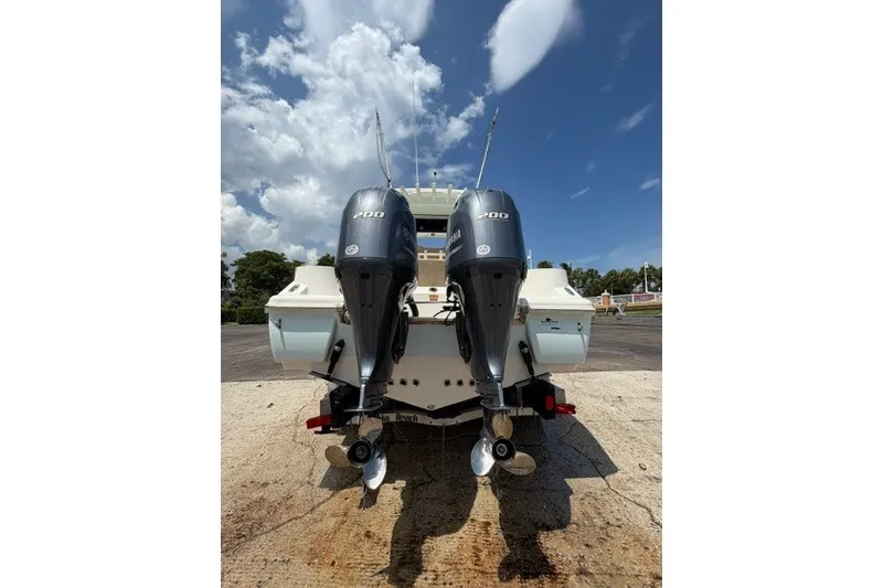 Slide: The Image of 2018 Key West 263 FS boat with dual 200 horsepower outboard engines, parked on a sunny day. - 14