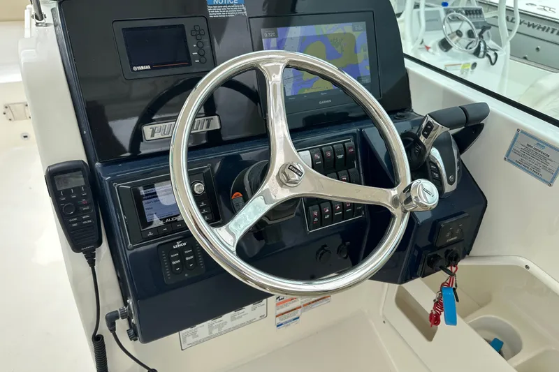 Slide: The Image of 2021 Pursuit DC 266 Dual Console helm with steering wheel and navigation controls. - 17