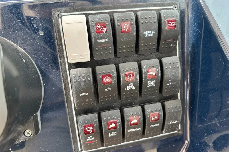 Slide: The Image of Control panel of a 2021 Pursuit DC 266 Dual Console boat with labeled switches. - 18