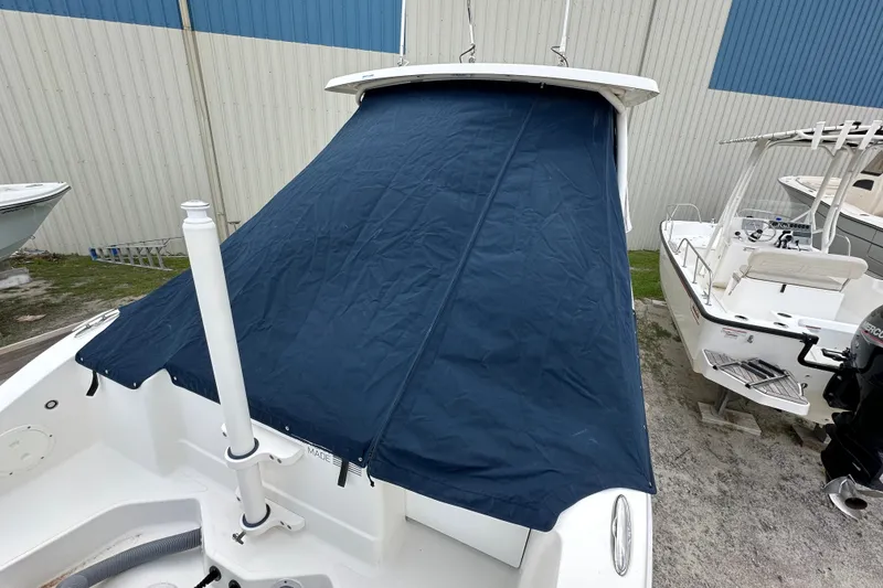 Slide: The Image of 2021 Pursuit DC 266 Dual Console boat with blue cover, docked outdoors. - 14