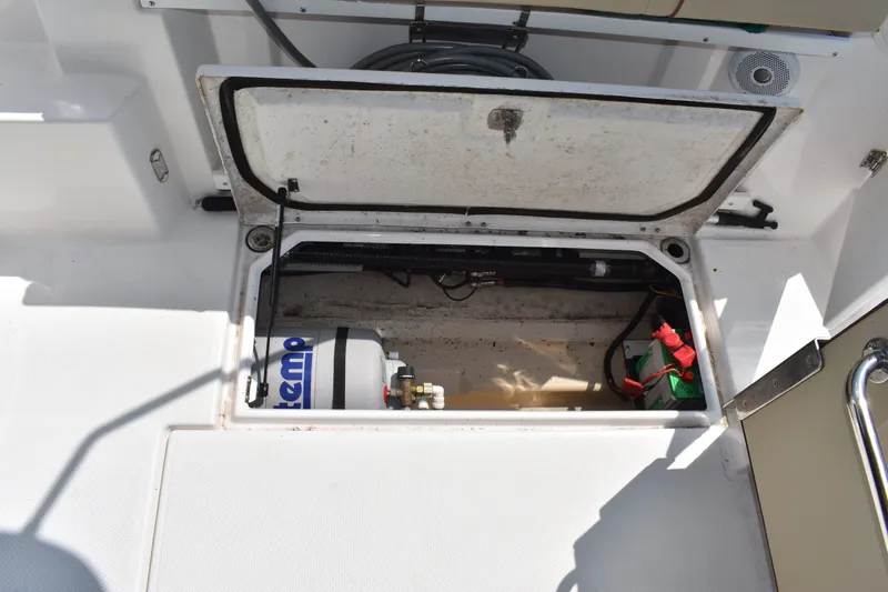 Slide: The Image of Open storage compartment on 2019 Ranger Tugs R-27 boat, revealing equipment and wiring. - 26