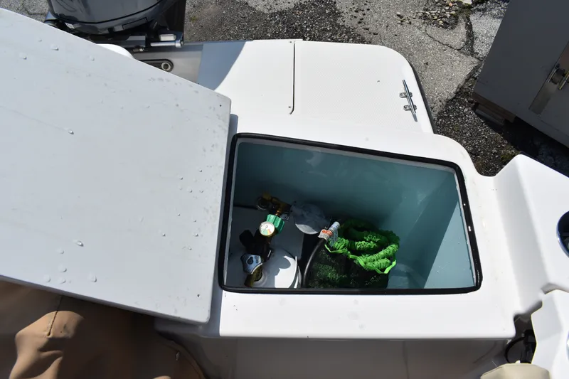 Slide: The Image of Open storage compartment on 2019 Ranger Tugs R-27 boat with various items inside. - 18