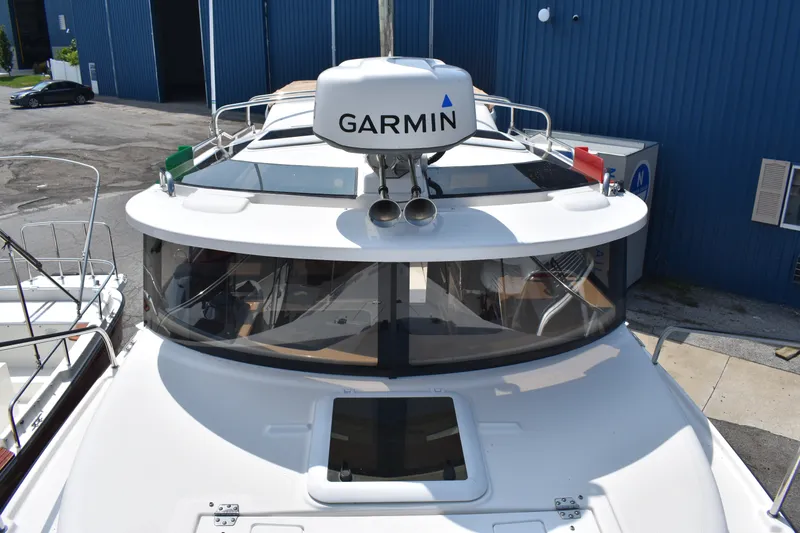 Slide: The Image of 2019 Ranger Tugs R-27 boat with Garmin radar, docked near blue building. - 48