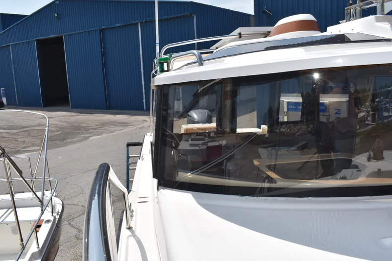 Slide: The Image of 2019 Ranger Tugs R-27 boat docked near blue warehouse, showcasing sleek design. - 50