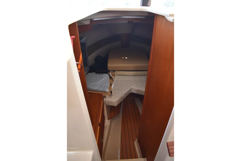Slide: The Image of 2019 Ranger Tugs R-27 cabin interior with wood finish and cozy sleeping area. - 40