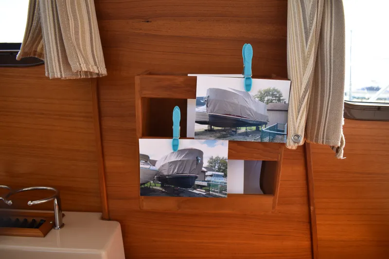 Slide: The Image of Interior of 2019 Ranger Tugs R-27 with photos clipped on wooden wall. - 28