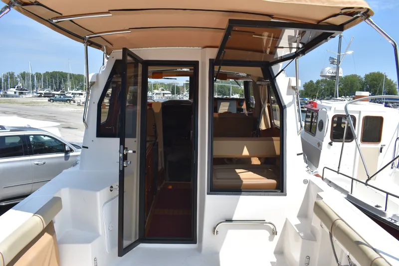 Slide: The Image of 2019 Ranger Tugs R-27 boat interior with open door, docked at marina. - 22