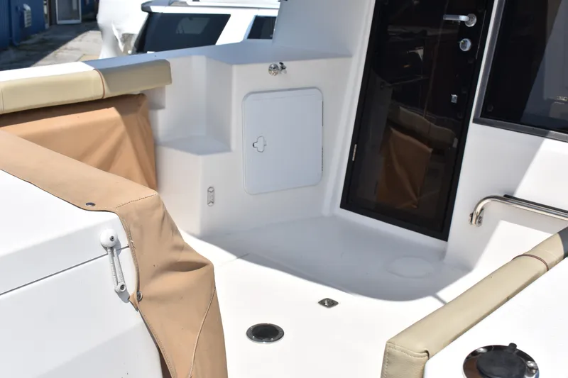Slide: The Image of 2019 Ranger Tugs R-27 boat interior with beige seating and storage compartments. - 8
