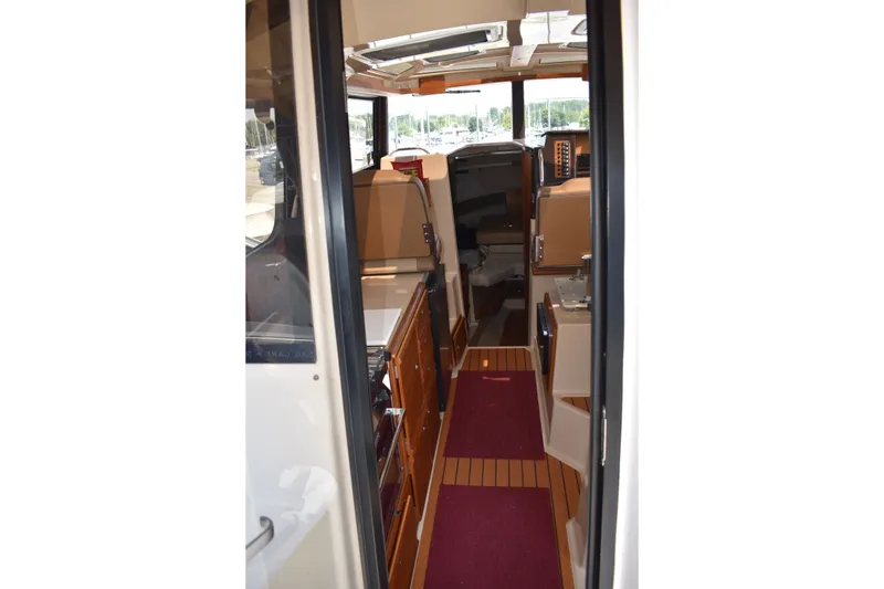 Slide: The Image of Interior view of 2019 Ranger Tugs R-27 boat, featuring wood cabinetry and seating. - 38