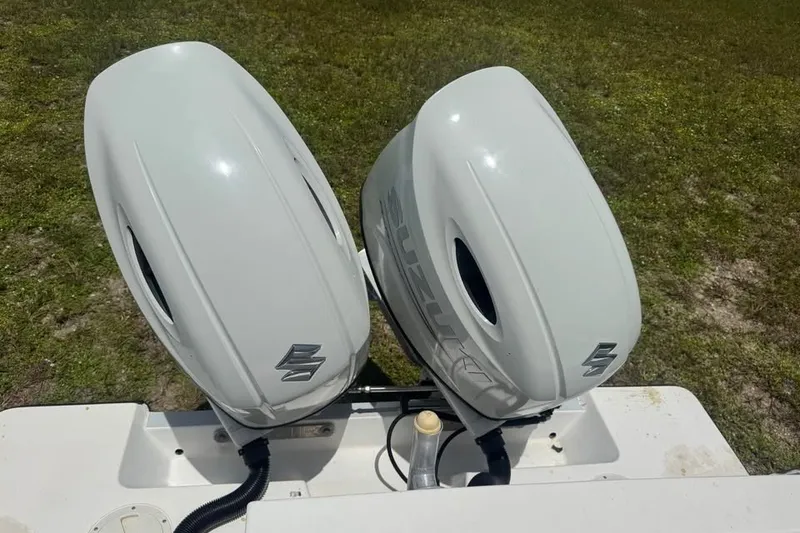 Slide: The Image of Twin Suzuki outboard motors on a 2007 Contender 23 Open boat, grassy background. - 3
