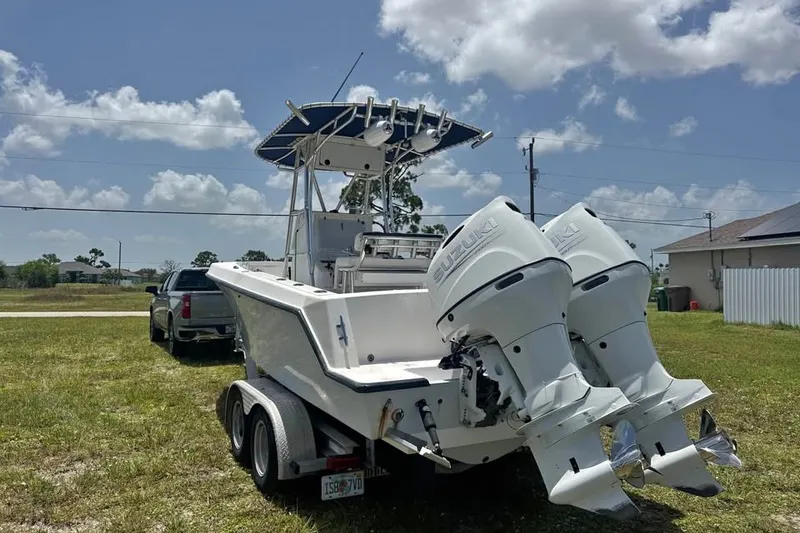 The Image of 2007 Contender 23 Open boat with twin Suzuki outboard engines on a trailer. - 0