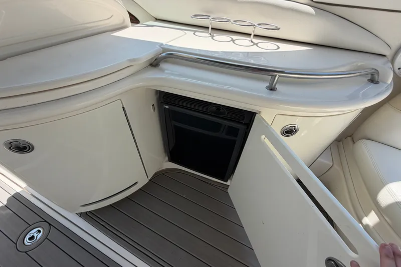 Slide: The Image of 2008 Sea Ray 290 SLX boat interior with open cabinet and built-in refrigerator. - 14