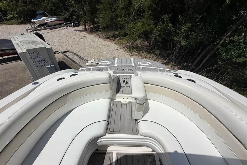 Slide: The Image of 2008 Sea Ray 290 SLX boat with white seating and gray deck, parked outdoors. - 24