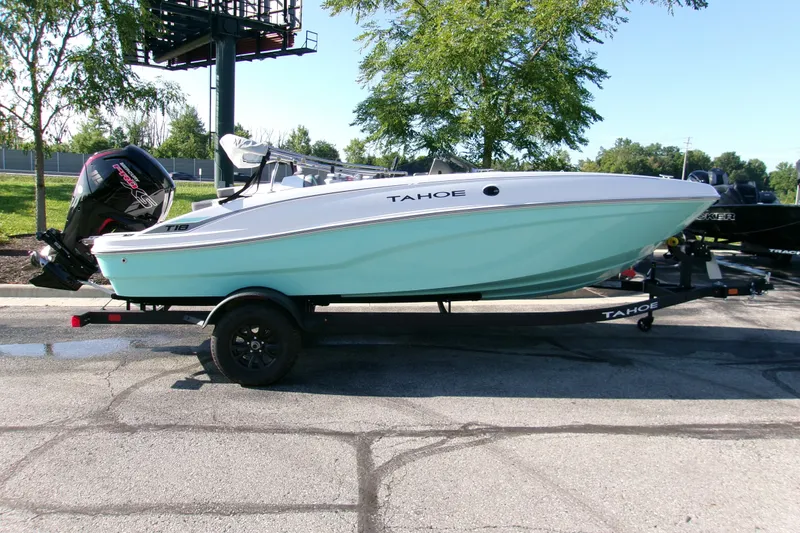 The Image of 2027 Tahoe T18 boat on trailer, parked outdoors, featuring sleek design and modern outboard motor. - 0