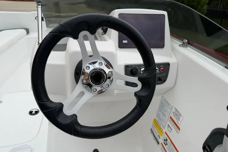 Slide: The Image of Steering wheel and dashboard of 2027 Tahoe T16 boat, featuring modern controls and display. - 14