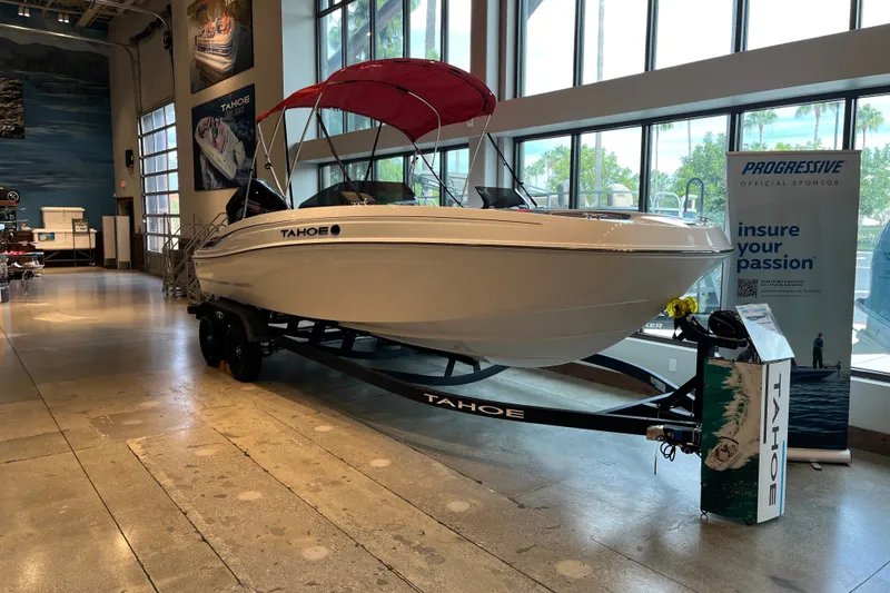 Slide: The Image of 2027 Tahoe T21 boat with red canopy on display indoors. - 1