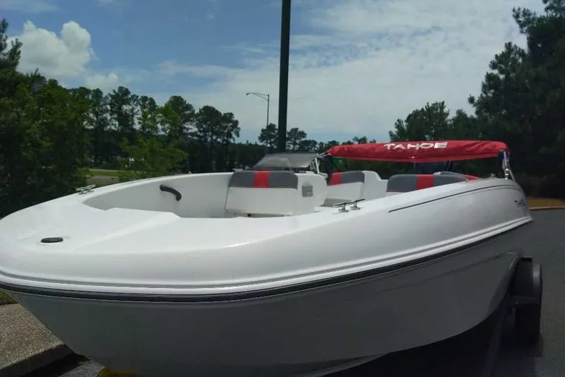 The Image of 2027 Tahoe T18 boat with red canopy, parked outdoors on a sunny day. - 0
