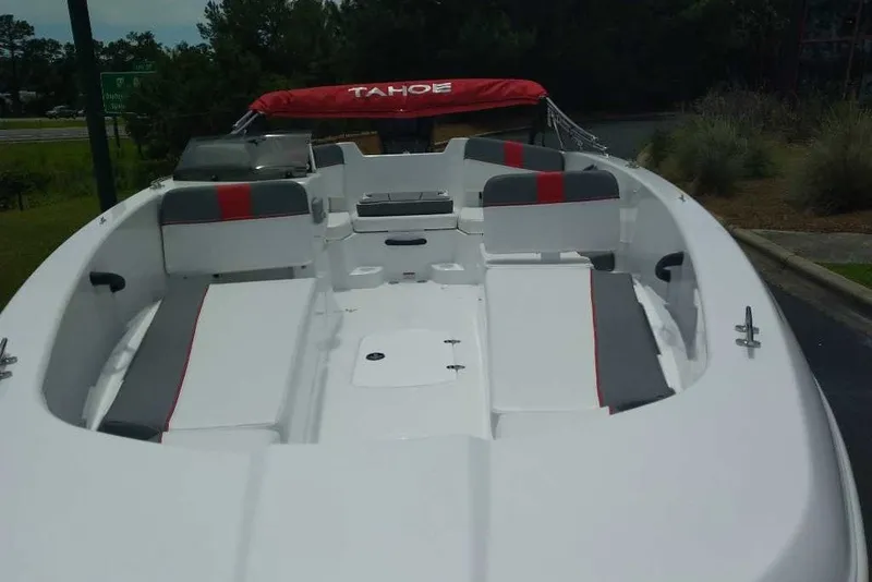 Slide: The Image of 2027 Tahoe T18 boat with red and gray seating, docked outdoors. - 5