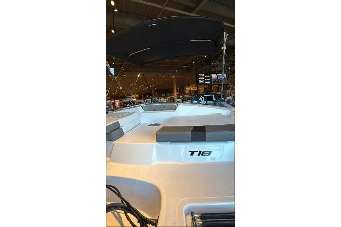 Slide: The Image of 2027 Tahoe T18 boat displayed indoors with canopy and seating. - 2