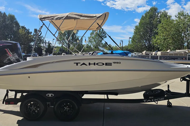 Slide: The Image of 2027 Tahoe 1950 boat on trailer, parked outdoors under clear blue sky. - 4