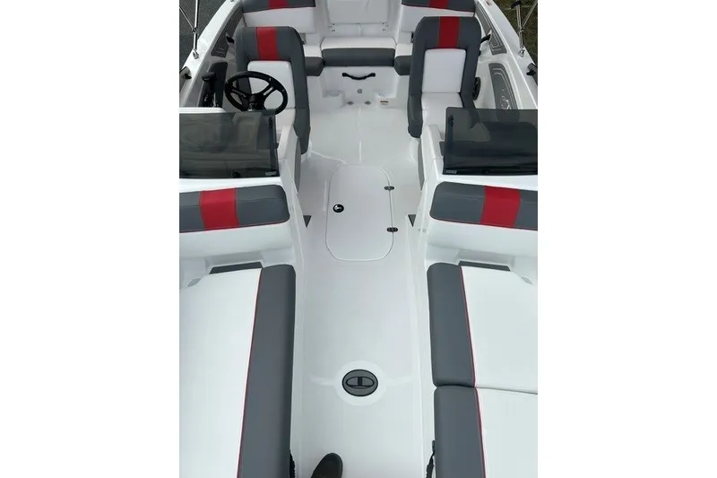 Slide: The Image of 2027 Tahoe T21 boat interior with gray and red seating, steering wheel, and storage compartments. - 7