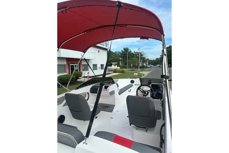 Slide: The Image of 2027 Tahoe T21 boat interior with red canopy and dual seating. - 8