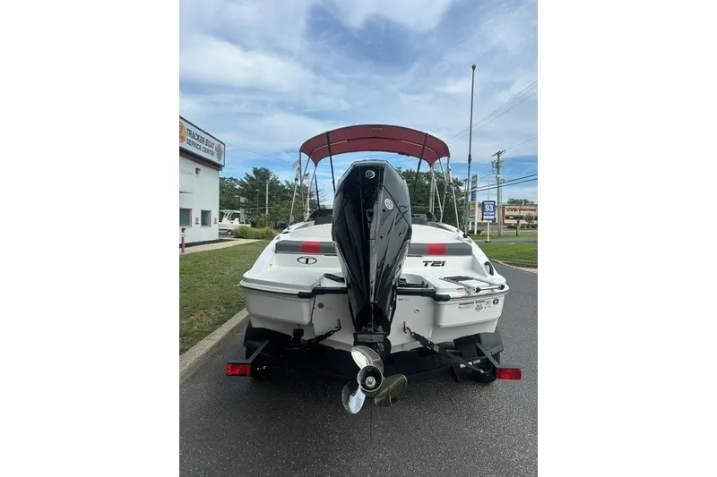 Slide: The Image of 2027 Tahoe T21 boat with outboard motor, parked near service center. - 3