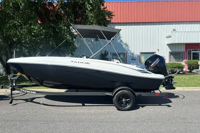 Slide: The Image of 2027 Tahoe T18 boat on trailer, parked outdoors near industrial building. - 1
