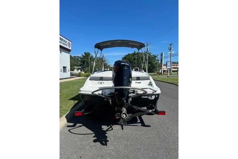 Slide: The Image of 2027 Tahoe T18 boat with outboard motor, parked on a sunny street. - 5