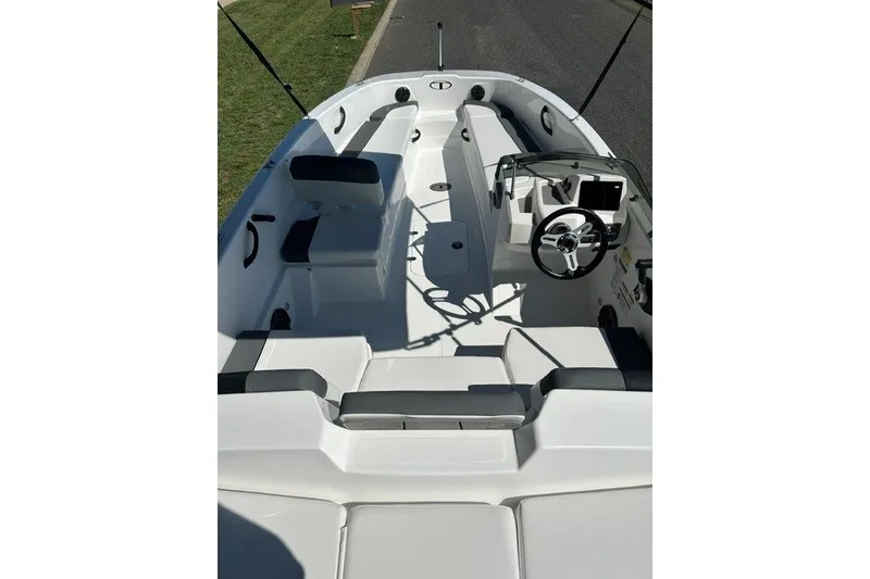 Slide: The Image of 2027 Tahoe T18 boat interior with seating, steering wheel, and console, parked on a road. - 7