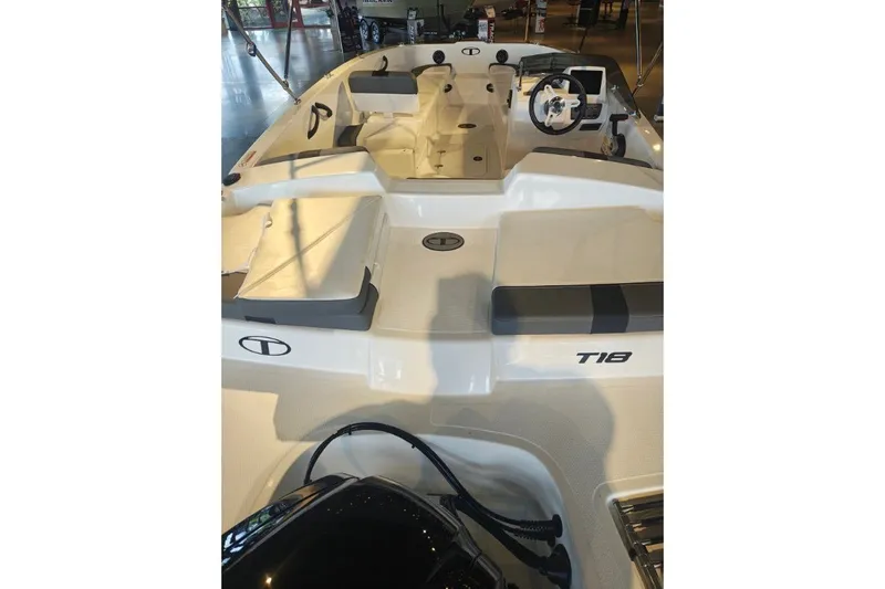 Slide: The Image of 2027 Tahoe T18 boat interior with seating and steering wheel in showroom. - 8