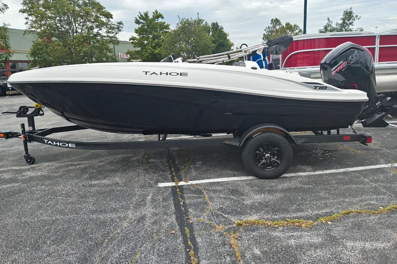 The Image of 2027 Tahoe T18 boat on trailer in parking lot, featuring sleek design and modern outboard motor. - 0