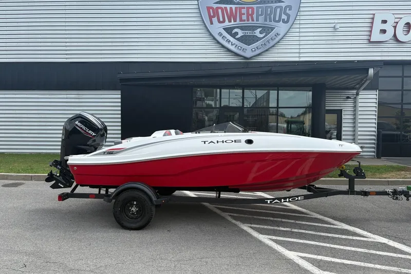 The Image of 2027 Tahoe T16 boat with red and white design on a trailer outside a service center. - 0