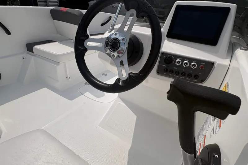 Slide: The Image of 2027 Tahoe T16 boat cockpit with steering wheel, control panel, and seating. - 6