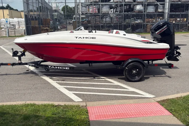 Slide: The Image of 2027 Tahoe T16 boat on trailer, red and white design, parked outdoors. - 1