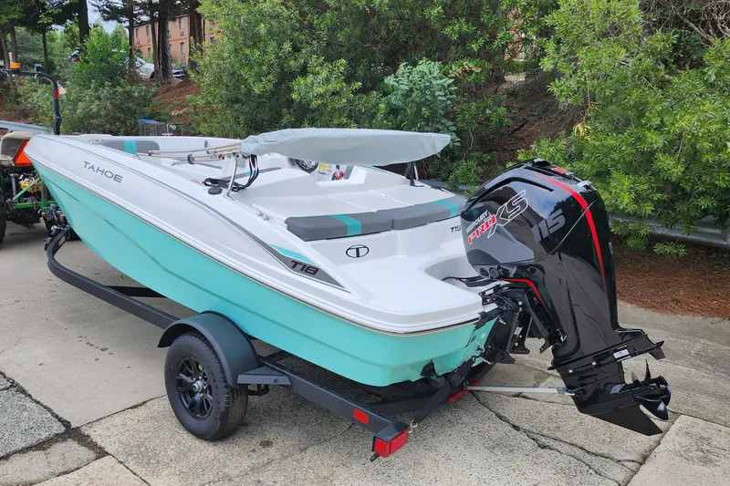 Slide: The Image of 2027 Tahoe T18 boat with Mercury 115 Pro XS engine on trailer, parked outdoors. - 2