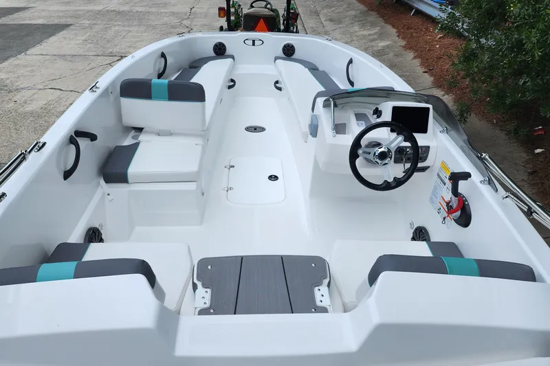 Slide: The Image of 2027 Tahoe T18 boat interior with modern seating and steering console, docked outdoors. - 3