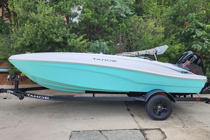The Image of 2027 Tahoe T18 boat on trailer, turquoise hull, parked outdoors. - 0