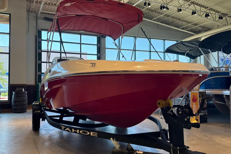 Slide: The Image of 2027 Tahoe T16 boat with red hull and canopy on display indoors. - 58
