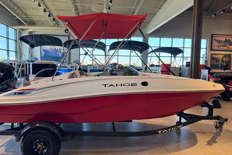 The Image of 2027 Tahoe T16 boat with red hull and canopy displayed indoors. - 57