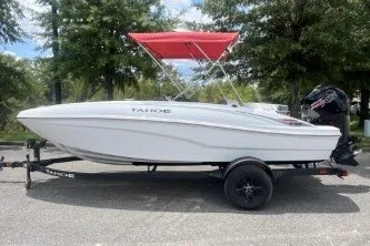 The Image of 2027 Tahoe T18 boat with red canopy on trailer, parked outdoors. - 0