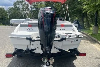 Slide: The Image of 2027 Tahoe T18 boat with outboard motor, parked on a trailer, under a red canopy. - 2