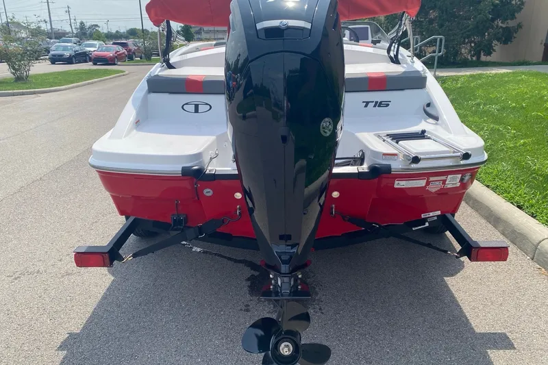 Slide: The Image of 2027 Tahoe T16 boat with outboard motor on a trailer, parked on a sunny street. - 5