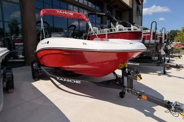 Slide: The Image of 2027 Tahoe T16 boat in red and white on a trailer, parked outdoors. - 0