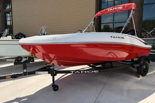 Slide: The Image of 2027 Tahoe T16 boat with red hull and trailer, parked outdoors. - 1
