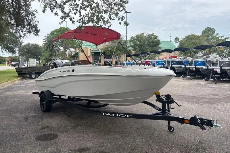 Slide: The Image of 2027 Tahoe T18 boat with red canopy on trailer in outdoor dealership lot. - 1