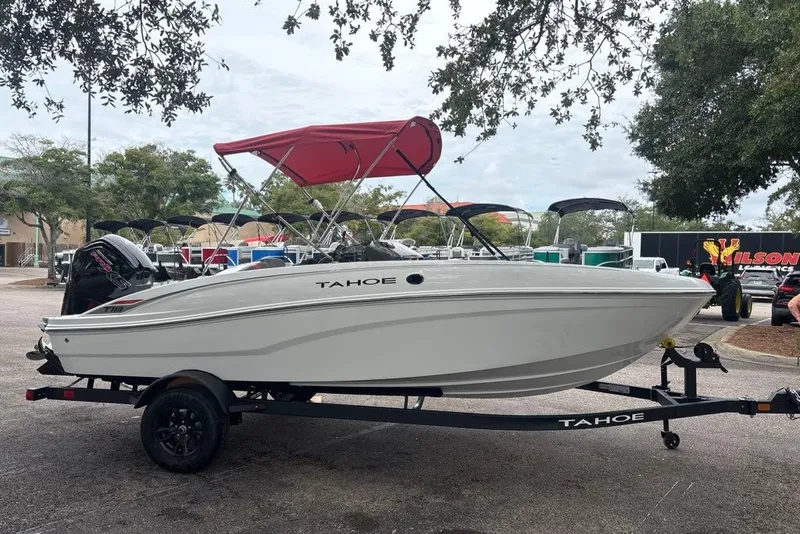 The Image of 2027 Tahoe T18 boat with red canopy on trailer, parked outdoors. - 0