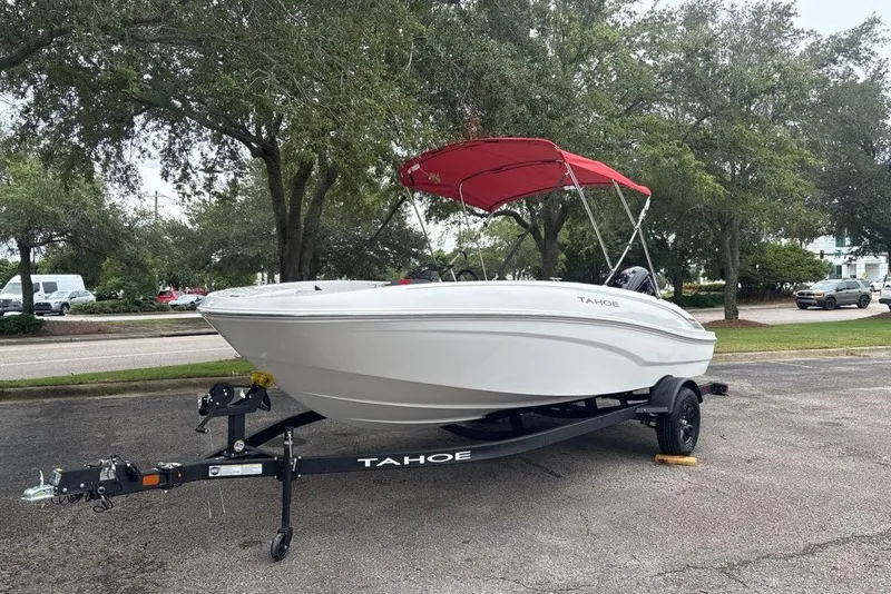Slide: The Image of 2027 Tahoe T18 boat with red canopy on trailer, parked outdoors. - 5