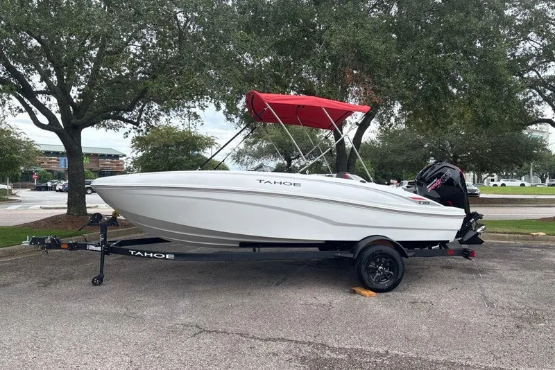 Slide: The Image of 2027 Tahoe T18 boat with red canopy on trailer in parking lot. - 4