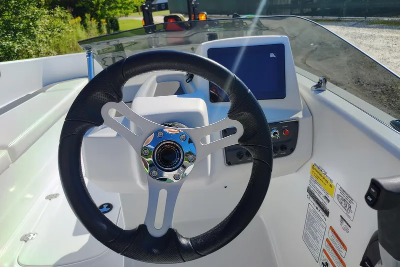 Slide: The Image of Steering wheel and dashboard of 2027 Tahoe T16 boat, featuring modern controls and display. - 5